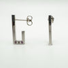Side view of sterling silver J hoop earrings showing post and pink sapphire and diamond detail
