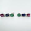 Side angle of ruby, sapphire, emerald and topaz earrings laid flat
