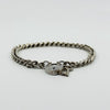 Low angle view of vintage sterling silver curb bracelet showing heart padlock, key charm and links.