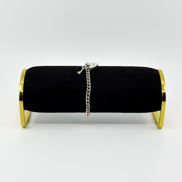 Side view of vintage sterling silver curb bracelet on black display stand with heart padlock visible.