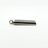 Angled side view of the silver ingot pendant showing the thick edge and hallmark panel.