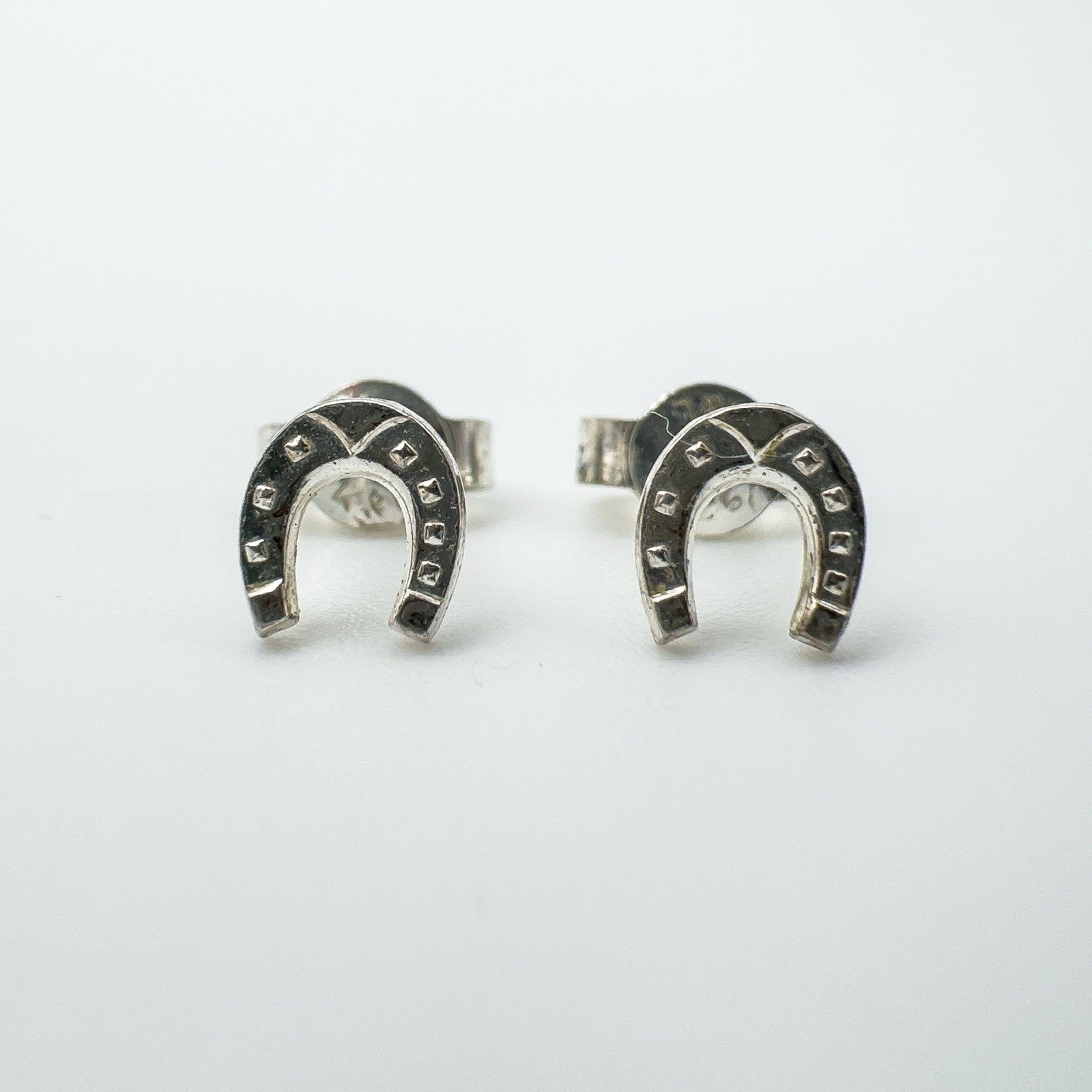 Pair of sterling silver mini horseshoe stud earrings front view