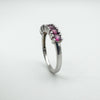 Angled upright view showing garnet stones raised slightly above the smooth silver band