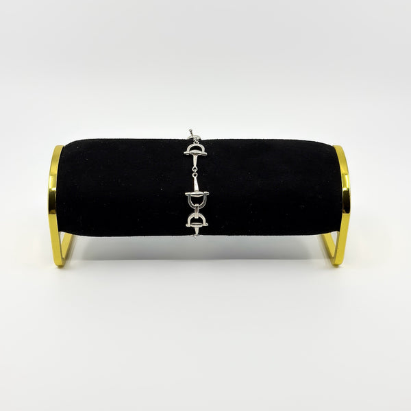 Vintage sterling silver horsebit snaffle bracelet shown on a black display stand.