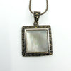 Sterling silver mother of pearl and marcasite square pendant close-up, showing bezel setting and stone border.