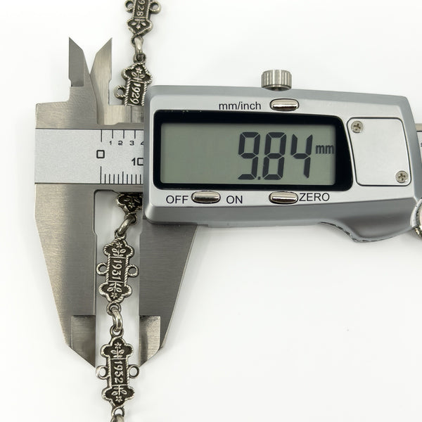 Digital caliper showing an Art Deco St Johns Ambulance examination bar measuring approximately 9.84mm wide.