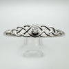 Celtic bangle with brilliant-cut CZ shown on clear display stand