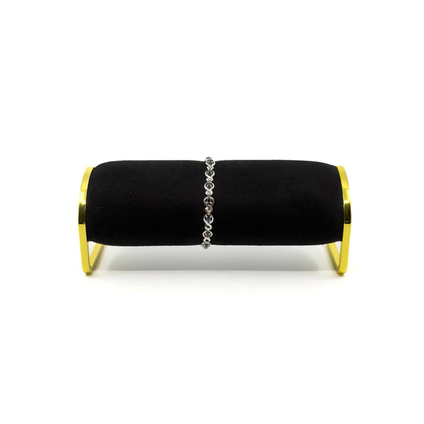 Sterling silver sapphire and diamond tennis bracelet shown on a black bracelet stand