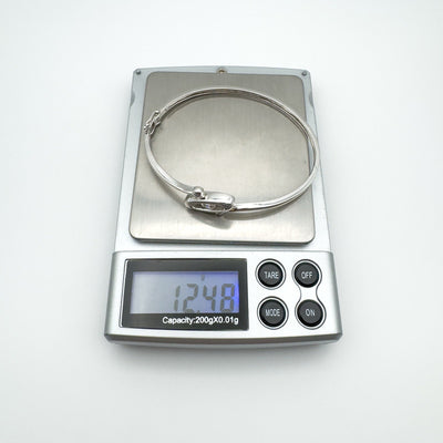 Sterling silver CZ bangle bracelet weighing approximately 12.48g on digital jewellery scale