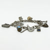 Vintage sterling silver oval link charm bracelet shown from the side with heart lock and hanging charms.
