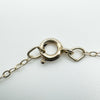Close-up of spring clasp on sterling silver chain with "STERLING" stamp visible