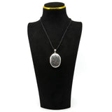 Sterling silver oval engraved photo locket shown on a black jewellery display bust