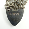Close up of ASJ, lion passant, anchor and date letter D hallmarks on sterling silver heart lock.