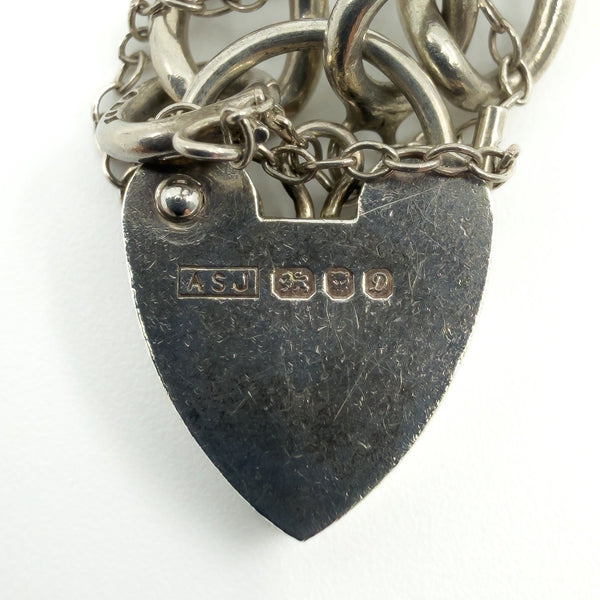 Close up of ASJ, lion passant, anchor and date letter D hallmarks on sterling silver heart lock.