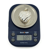 Sterling silver puffy heart locket on digital scales weighing approximately 6.89g