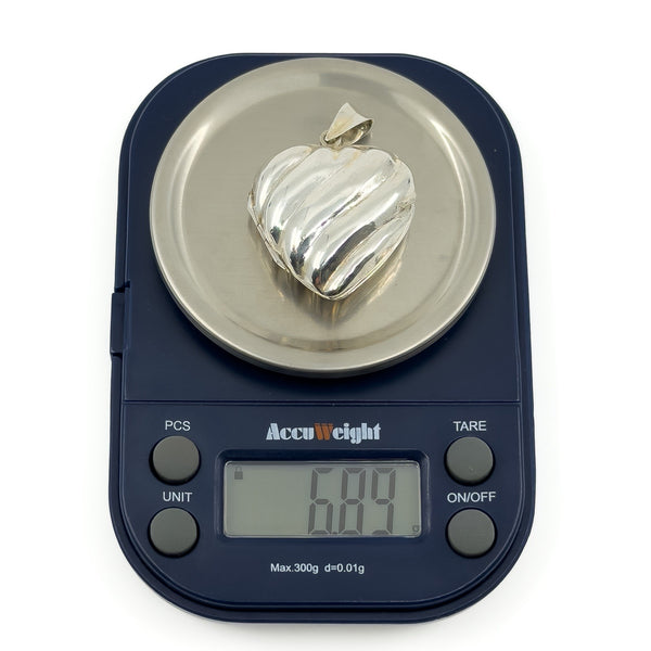 Sterling silver puffy heart locket on digital scales weighing approximately 6.89g