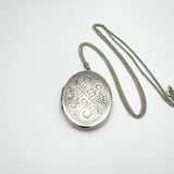 Engraved vintage oval locket shown on 24 inch curb chain