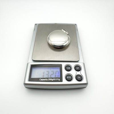 Sterling silver mirrored locket weighing 13.2 grams on digital scale