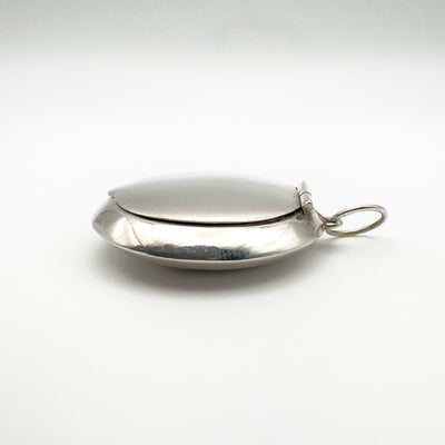Side view of sterling silver pill box locket with smooth domed design
