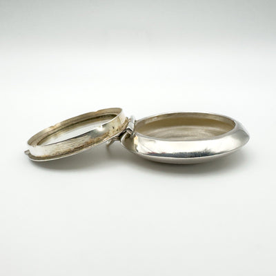 Open view of sterling silver locket showing mirror and hidden compartment