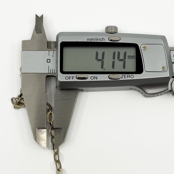 Caliper showing the oval link width on a vintage sterling silver bracelet at approximately 4.1mm