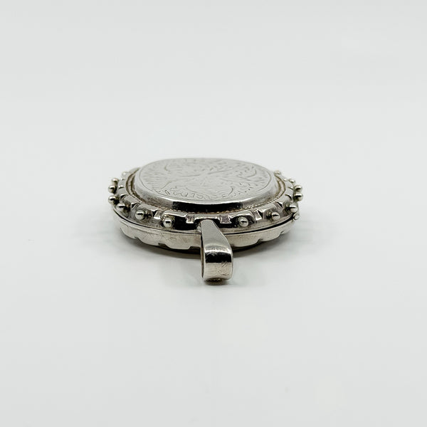 Side view of the vintage sterling silver oval locket showing the large bail and raised edge
