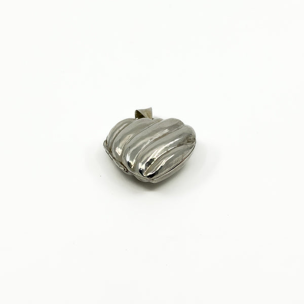 Angled view of the vintage sterling silver puffy heart locket with polished ridged front.