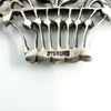 Close-up of STERLING stamp on the giardinetti basket brooch in sterling silver.