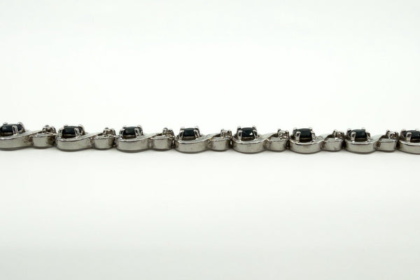 Side view of sterling silver sapphire and diamond tennis bracelet showing raised stone settings