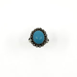 Front view of the turquoise cabochon and rough cut diamond halo ring