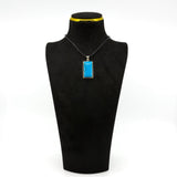 Sterling silver turquoise pendant displayed on a black bust, showing the bold rectangular blue stone