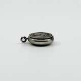 Side view of vintage sterling silver Virgin Mary photo locket pendant showing its rounded shape.