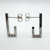 Pair of sterling silver J half hoop earrings with pink sapphires and diamond bezel set at the base