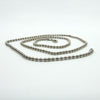 Sterling silver beaded ball chain necklace shown coiled, with lobster clasp visible.