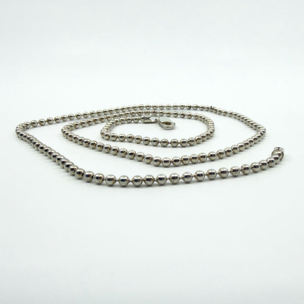 Sterling silver beaded ball chain necklace shown coiled, with lobster clasp visible.