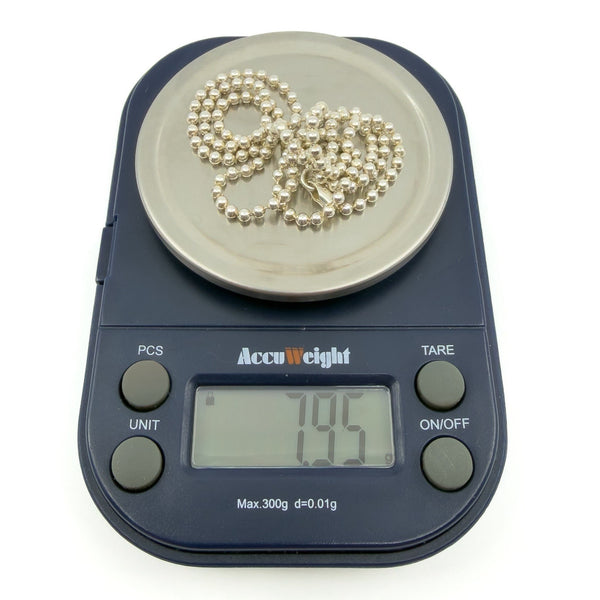 Sterling silver beaded ball chain necklace shown on scales, weight approximately 7.95g.