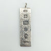 Close-up of solid sterling silver ingot pendant with Sheffield 1977 hallmarks and bark-textured finish
