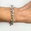 Twisted and ball-accented sterling silver bracelet worn for size reference on wrist