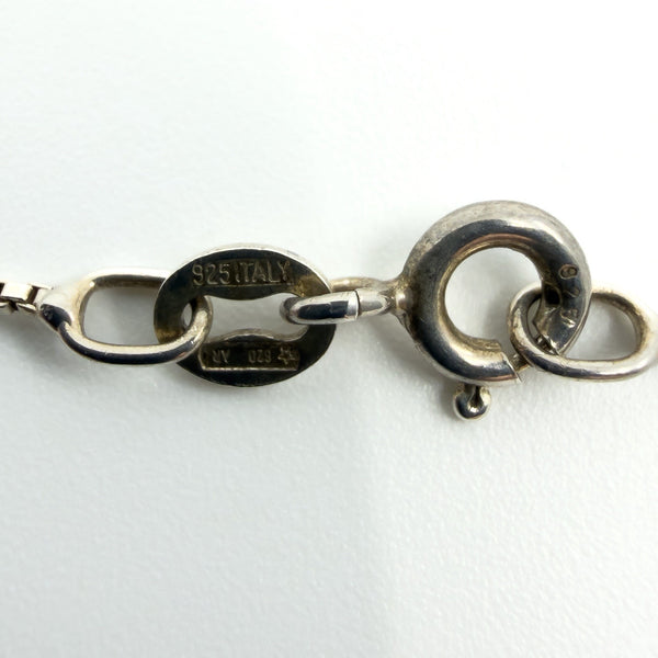 Close-up of necklace clasp and tag stamped “925 ITALY” on sterling silver box chain.