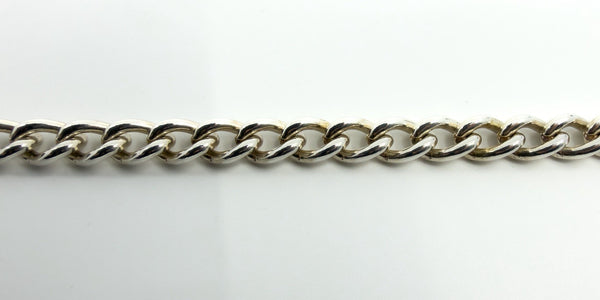 Close-up of chunky sterling silver curb links showing polished finish and link profile.