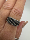 Hand shot showing striped cognac and white diamond ring worn on middle finger