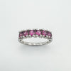 Front view of sterling silver ring set with 6 round cut pink rhodolite garnets in a half hoop design