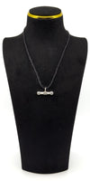 Sterling silver T-bar charm shown hanging on a cord on a black jewellery bust.
