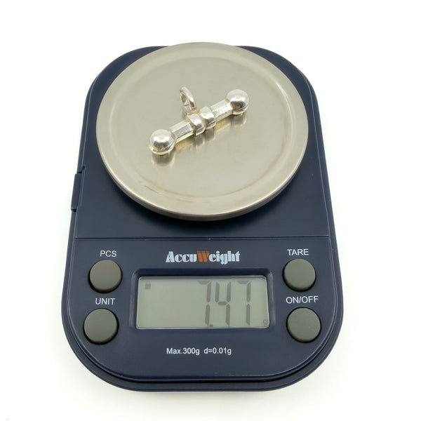 Sterling silver T-bar pendant on digital scales showing an approximate weight of 7.47g.