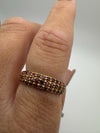 Close-up of ruby pavé eternity band worn on hand, highlighting stones