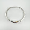 Oval-shaped sterling silver buckle bangle laid flat