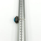Side view of the sterling silver turquoise diamond halo ring on a UK ring mandrel