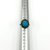 Sterling silver turquoise diamond halo ring shown on a UK ring mandrel at size L - M
