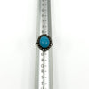 Sterling silver turquoise diamond halo ring shown on a UK ring mandrel at size L - M