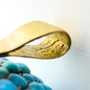 Close-up inside the gold bail showing the crown and 18 stamps on the Victorian turquoise tassel locket.